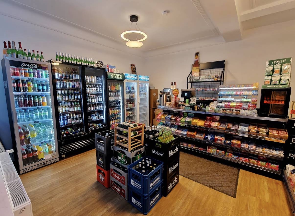 Heller Innenraum des Elbview Kiosk mit gut gefüllten Kühlschränken, Getränkekisten und Snack-Regalen